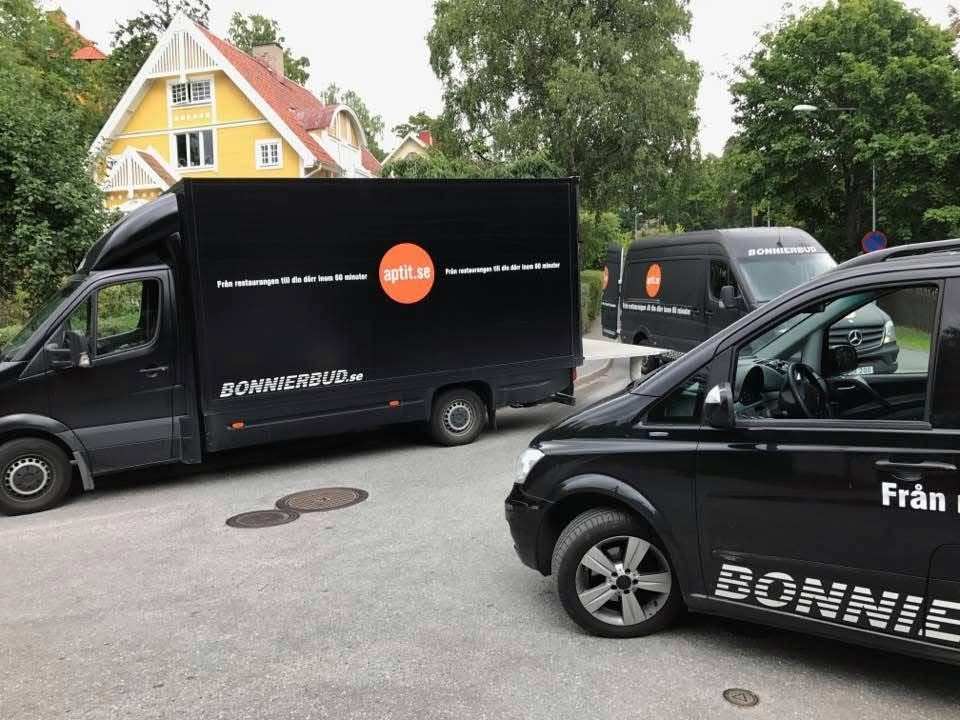 Svarta budbilar med Bonnier Buds logotyp.
